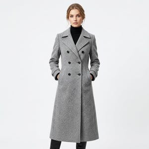 May include: A long, double-breasted gray wool-blend coat featuring a notched lapel, structured shoulders, and six black buttons. The coat has long sleeves with buttoned cuffs, two side pockets, and a tailored fit that reaches below the knee.