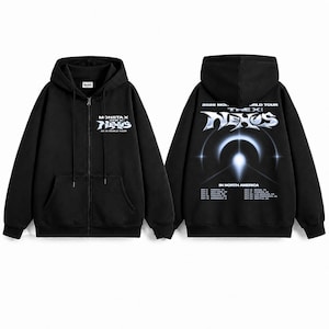 May include: A black zip-up hoodie featuring a Monsta X The X: Nexus 2026 World Tour graphic on the front left chest. The back displays a large metallic Nexus logo, a glowing light effect, and a list of North American tour dates and locations.