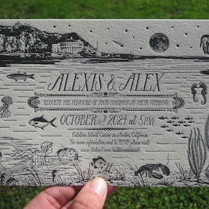 May include: A black and white wedding invitation with a nautical theme. The invitation features a stylized illustration of a moon, stars, a heron, a mermaid, seahorses, and fish. The text on the invitation reads "ALEXIS & ALEX REQUEST THE PLEASURE OF YOUR COMPANY AT THEIR WEDDING OCTOBER 2024 at 5PM Catalina Island Casino in Avalon, California For more information and to RSVP please visit www.theknot.com/"