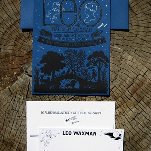 May include: A blue and black illustrated birth announcement card with the name "Leo Waxman" and the text "We welcome with love" and "Born August 8, 2014, 7 lbs 12 oz, 19.5 in". The card features a black silhouette of a forest scene with a moon and stars.