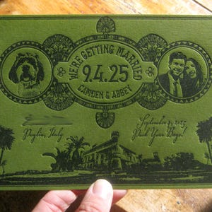 May include: Green wedding invitation with a gold embossed design. The invitation reads "We're getting married 9.4.25 Camden & Abbey" and includes a dog and a couple's portrait.