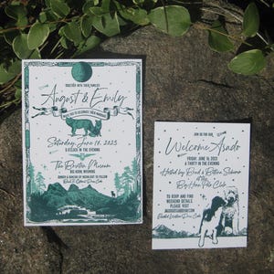 May include: Two-piece wedding invitation set with a teal and white design. The main invitation features the names "August & Emily" and event details. The smaller card says "Welcome Asado" with event information and dog illustrations.