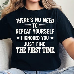 May include: Black t-shirt with white text that reads "THERE'S NO NEED TO REPEAT YOURSELF I IGNORED YOU JUST FINE THE FIRST TIME." The text is centered and in a bold, sans-serif font.