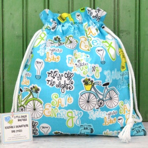 May include: A blue drawstring bag with a white cord. The bag is printed with a pattern of bicycles, light bulbs, and the text "Turn off the lights, Save Energy, Ride your bike".