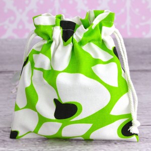 May include: A green and white drawstring bag with a floral pattern. The bag is made of fabric and has a white drawstring.