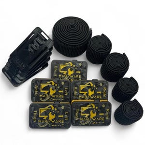 Könnte beinhalten: Ein Set aus schwarzer und goldener Hardware für einen Fitness-Tracker. Das Set enthält sechs schwarze Bänder, vier schwarze und goldene Tracker und vier schwarze Plastikclips. Die Tracker sind mit "Brust", "Knöchel", "Oberschenkel" und "Links" oder "Rechts" beschriftet.