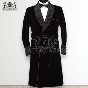 Puede incluir: Una bata de terciopelo negro con ribete rojo y cuello acolchado. La bata tiene un cinturón a juego y el texto "CUSTOMCRAFT6" es visible. Debajo se lleva una camisa blanca y una pajarita.