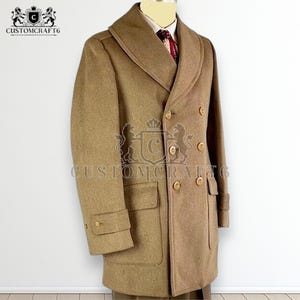 May include: A tan double-breasted overcoat with a wide lapel and wooden buttons. The coat has two front pockets and cuff detailing on the sleeves. The text "CUSTOMCRAFT6" is visible on the coat.