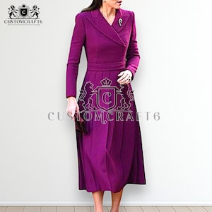 May include: A long-sleeved, knee-length dress in a vibrant purple hue. The dress features a tailored bodice with a notched collar and a defined waist. The skirt is pleated, and a decorative brooch adorns the lapel. The text "CUSTOMCRAFT6" is visible.