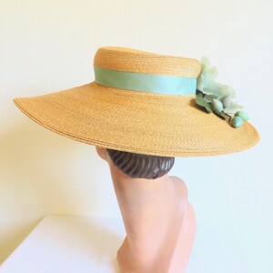 Peut inclure: Un chapeau de paille &agrave; larges bords avec un ruban bleu clair et une fleur bleue clair.