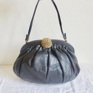 Cartera de cuero negra de los años 60 con forma de almeja y asa superior con cierre de metal dorado, estilo retro, estilo años 60, MCM Ingber USA