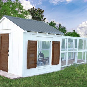 Può includere: Un pollaio bianco con tetto in metallo grigio, persiane marroni e una porta. Il pollaio ha un recinto in rete metallica. La struttura è situata su un prato erboso con alberi e cielo blu sullo sfondo.