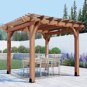 May include: A wooden pergola with a slatted roof, supported by four sturdy posts. A table and chairs are set up inside the pergola, creating an outdoor dining area. The structure is made of light brown wood and is set on a stone patio.