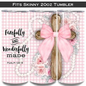 May include: A pink and white gingham tumbler featuring a wooden cross with a pink bow, surrounded by flowers and pearls. The tumbler has the text "Fearfully and Wonderfully made" and "Psalm 139:14". Fits a 20oz skinny tumbler.