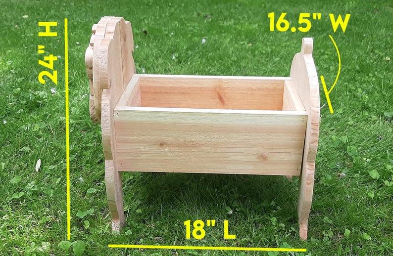 K&ouml;nnte beinhalten: Eine Holz-Pflanzkasten, 61 cm hoch, 42 cm breit und 46 cm lang. Der Pflanzkasten ist aus hellem Holz gefertigt und mit dekorativen Seitenteilen versehen. Er steht auf einer grasbewachsenen Oberfl&auml;che.