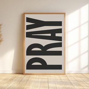 Arte de pared beige con la frase "ORA": Lámina minimalista con versículo bíblico cristiano.