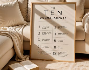 May include: A framed print with the text "THE TEN COMMANDMENTS" in a minimalist style. The print is in a light beige color with black text and is displayed against a neutral-toned background. The print is in a wooden frame.