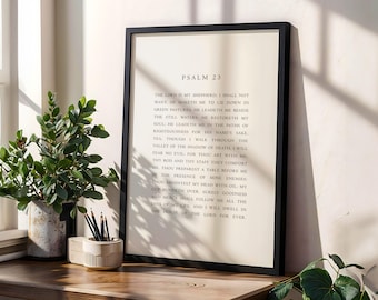 Puede incluir: Una impresión enmarcada con el texto del Salmo 23 en un marco negro. La impresión se muestra sobre una superficie de madera junto a una planta en maceta y un pequeño recipiente decorativo con lápices.