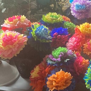 Puede incluir: Una colecci&oacute;n de flores de papel de seda de colores en varios tonos de rosa, amarillo, azul, verde y naranja. Las flores est&aacute;n dispuestas en un ramo y son una decoraci&oacute;n popular para fiestas y eventos.