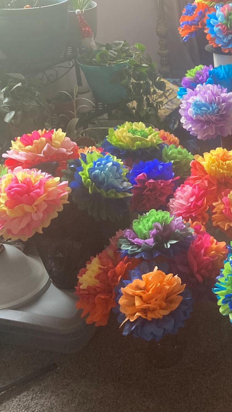 Puede incluir: Una colecci&oacute;n de flores de papel de seda de colores en varios tonos de rosa, amarillo, azul, verde y naranja. Las flores est&aacute;n dispuestas en un ramo y son una decoraci&oacute;n popular para fiestas y eventos.
