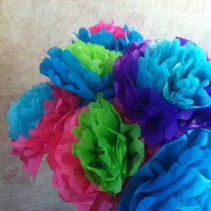 Puede incluir: Un ramo de flores de papel de seda en una variedad de colores, incluyendo rosa, azul, verde y morado. Las flores est&aacute;n dispuestas en un jarr&oacute;n y son una decoraci&oacute;n festiva.