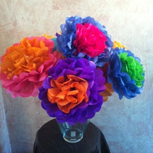 Puede incluir: Un ramo de flores de papel de seda de colores en un jarr&oacute;n de vidrio transparente. Las flores son en tonos de naranja, rosa, morado, azul y verde.