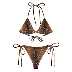 May include: A two-piece bikini set with a brown and white spotted pattern. The top is a triangle style with halter straps and a tie closure. The bottoms are a classic cut with tie sides. The swimwear is designed with a deer-like pattern.