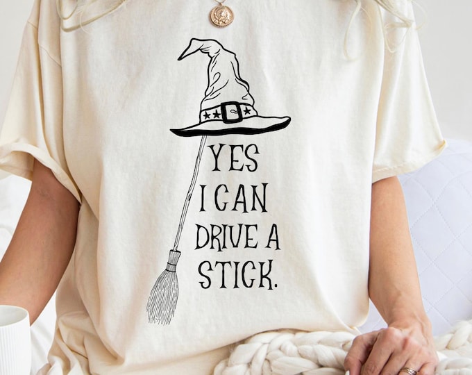 Yes I Can Drive a Stick Halloween Shirt: Spooky Season Witch Girls Cotton Tee