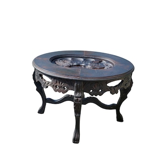 May include: A dark wood oval coffee table with intricate carvings on the legs and a carved design on the top.
