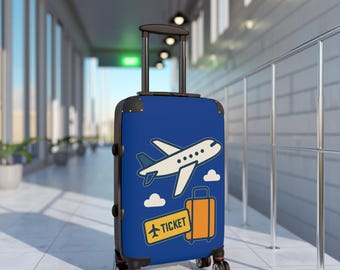 May include: A blue rolling suitcase with a travel theme. The suitcase features a white airplane, clouds, and an orange suitcase graphic. A yellow rectangle with the word "TICKET" is also on the front.