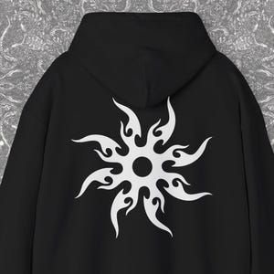 May include: Black hoodie featuring a white sunburst design on the back. The hoodie has a hood and long sleeves. The Blackash Records logo is in the lower right corner.
