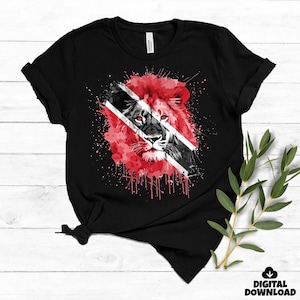 May include: Black t-shirt featuring a lion graphic with red, black, and white accents. The lion's mane is red, and the design incorporates the flag of Trinidad and Tobago. The shirt has short sleeves and a crew neck.