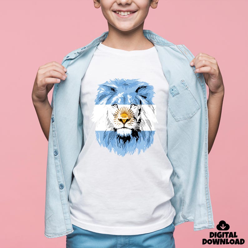 May include: White t-shirt featuring a lion design with the Argentinian flag incorporated into the mane. The lion's face is centered, with the flag's blue and white stripes forming the mane. The design includes a sun emblem.