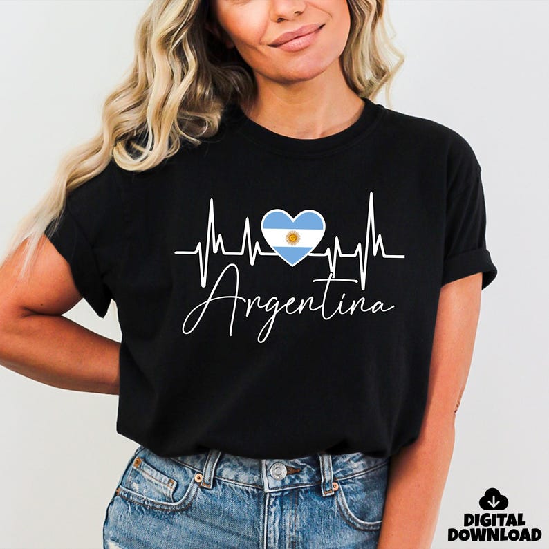 May include: Black t-shirt featuring a white heartbeat design with a blue and white heart representing the Argentina flag. The word "Argentina" is written in cursive below the heartbeat graphic.
