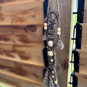 Macrame door knob hanger.  Can be hung anywhere.  Small and fun little addition to any space. Overall dimensions 2”x 14”