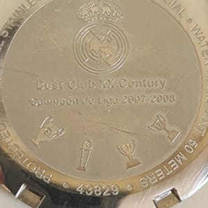 May include: A stainless steel watch back with the text "Best Club XX Century" and "Campe&oacute;n de Liga 2007-2008". The watch back also features a team crest and the text "STAINLESS STEEL &bull; RELOJ OFICIAL".