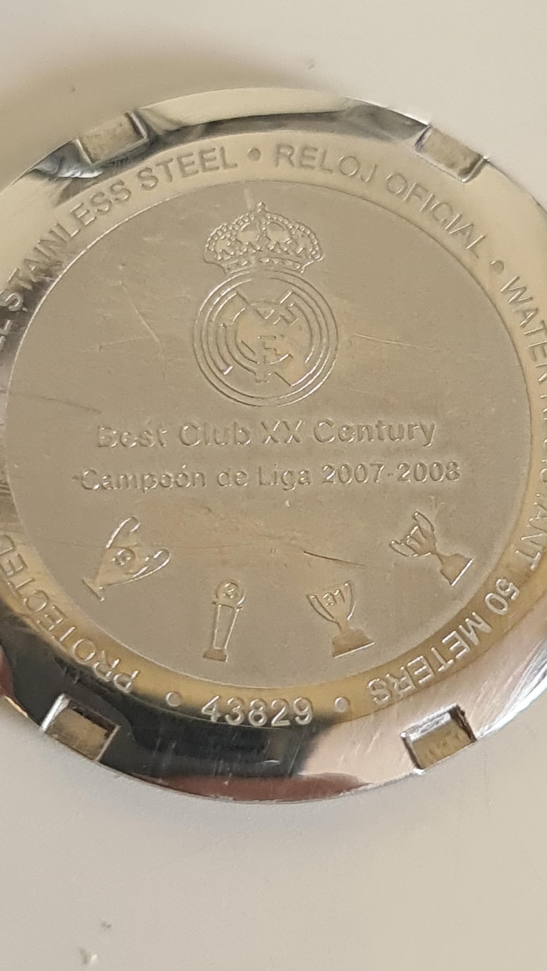 May include: A stainless steel watch back with the text "Best Club XX Century" and "Campe&oacute;n de Liga 2007-2008". The watch back also features a team crest and the text "STAINLESS STEEL &bull; RELOJ OFICIAL".
