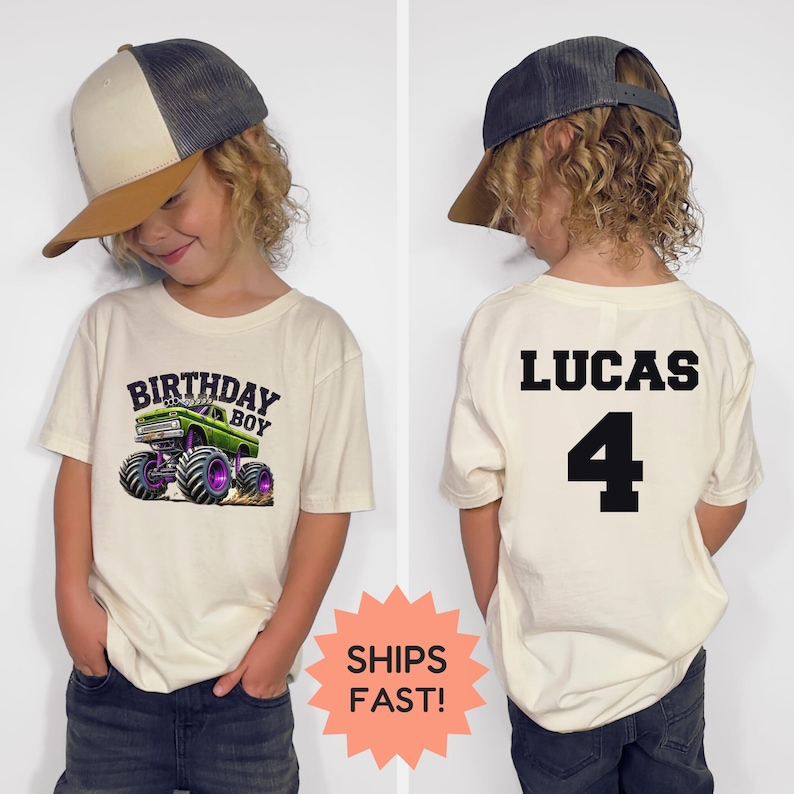 K&ouml;nnte beinhalten: Cremefarbenes T-Shirt mit einem gr&uuml;nen Monster-Truck-Motiv und dem Text "BIRTHDAY BOY". Auf der R&uuml;ckseite des Shirts stehen der Name "LUCAS" und die Zahl "4" in Schwarz. Das Kind tr&auml;gt eine Baseballkappe.
