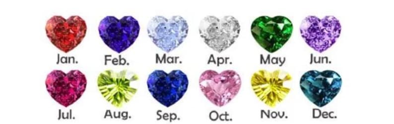 May include: A collection of heart-shaped gemstones in various colors, each representing a month of the year. The months are labeled from January to December, with each gemstone displaying a unique hue, including red, blue, green, and purple.