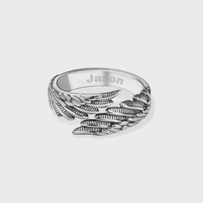 Puede incluir: Anillo plateado con dise&ntilde;o de alas. El anillo tiene el nombre "Jason" grabado en el interior. El dise&ntilde;o de alas envuelve el dedo, creando un aspecto &uacute;nico y elegante.