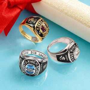May include: Three class rings with black enamel and various colored stones. One ring is gold-toned with a purple stone and the text "MORSE HIGH SCHOOL 2024". Another ring is silver-toned with a blue stone and the text "HAUGHTON HIGH SCHOOL 2024". The third ring is silver-toned with a clear stone and the text "HORSE HIGH 2024".