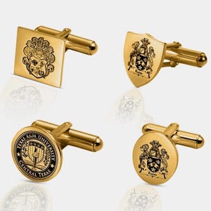 K&ouml;nnte beinhalten: Vier goldfarbene Manschettenkn&ouml;pfe mit verschiedenen eingravierten Designs. Einer ist quadratisch mit Wappen, ein anderer schildf&ouml;rmig mit Wappen und dem Namen "Bates", und zwei sind rund mit Wappen und Text, einschlie&szlig;lich "Texas A&M University Central Texas".