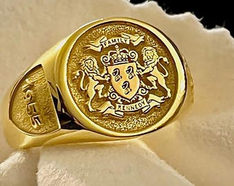 Peut inclure: Une bague chevalière en or avec un plateau circulaire gravé d'armoiries, deux lions, une couronne et le texte FAMILY KENNEDY. Le côté de l'anneau est gravé de l'année 1955 dans un style de police en creux et audacieux.