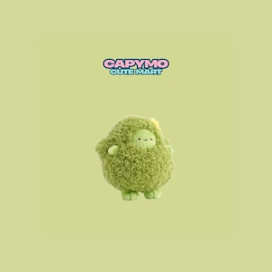 Puede incluir: Un peluche verde con forma de aguacate con una cara sonriente, brazos y pies pequeños. El juguete tiene una textura difusa y una pequeña flor amarilla. El texto "CAPYMO CUTE MART" se muestra encima del juguete.