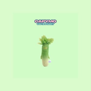 May include: A green leek-shaped plush toy with a smiling face and leafy top. The toy has a light green body and a beige base. The text "CAPYMO CUTE MART" is above the toy on a light green background.