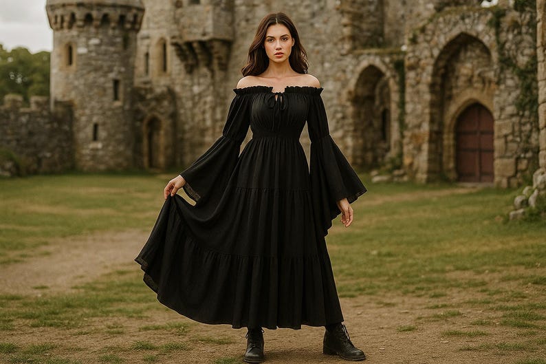 Puede incluir: Un vestido negro con hombros descubiertos, mangas largas y acampanadas y una falda escalonada. El vestido se lleva con botas negras. El fondo presenta un castillo de piedra y hierba verde.