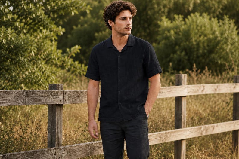 May include: A short-sleeved button-down shirt in a solid dark navy blue color featuring a classic collar, a front button placket, and a straight hemline, paired with matching dark navy blue trousers that have a simple, clean-cut design.