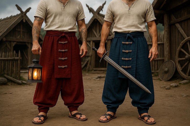 May include: Two people wearing beige shirts, red and blue pants, and sandals. One holds a lit lantern, the other a sword. The pants have decorative closures. The background features wooden structures and a dirt ground.
