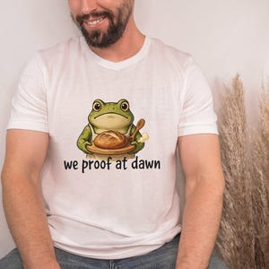 Wir prüfen im Morgengrauen Frosch-Bäcker-lustiges Backen-T-Shirt, niedliches Cottagecore Brot-Frosch-grafisches T-Stück, Bäcker-Geschenk-Shirt