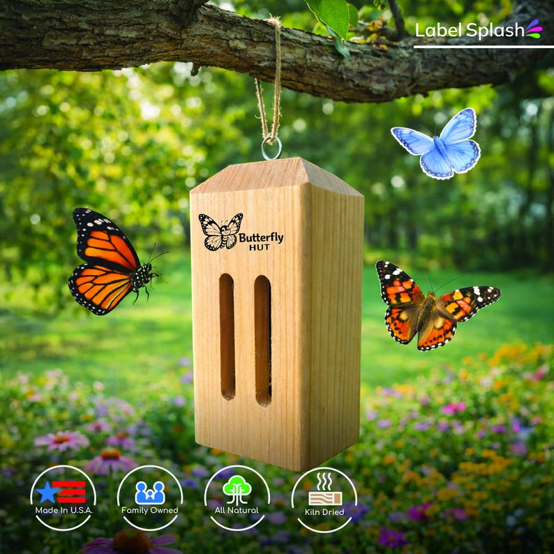 Puede incluir: Una casita de madera para mariposas con el texto "Butterfly HUT" y dos aberturas verticales. La casita est&aacute; colgada de una rama de &aacute;rbol con mariposas volando alrededor. Hecho en EE. UU.